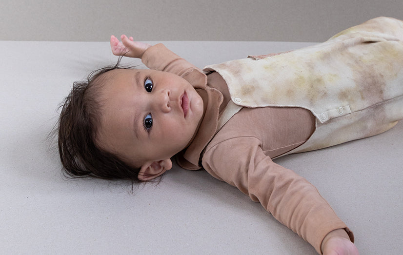 Baby wearing an organic Gray Label RNTD x Hu Le Kes item